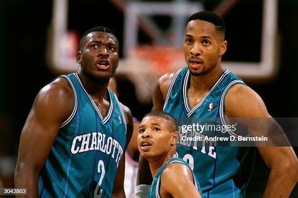 Larry Johnson, 'Mugsy' Bogues and Alonzo Mourning of the Charlotte Hornets take a break during an NBA game circa 1993 at The Charlotte Coliseum in...