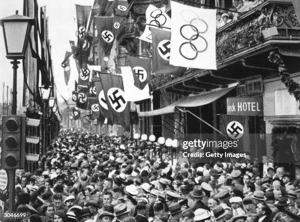 General view of crowd on a street in Berlin as Germany hosts the XI Olympic Games in August of 1936 in Berlin, Germany.