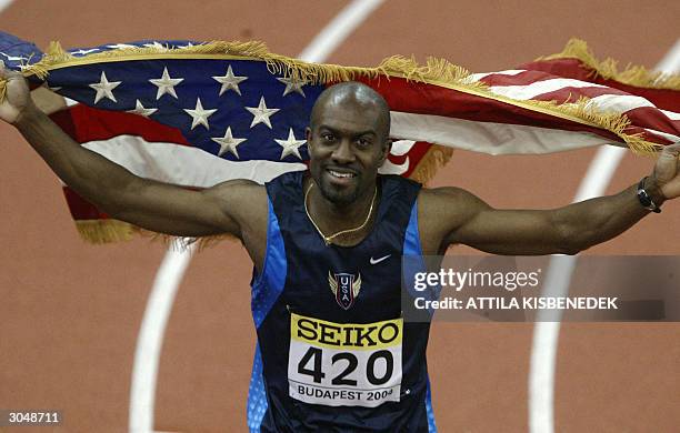 Allen Johnson of the US celebrates with his national flag after winning the final of the men's 60m hurdles in 7.36sec, 06 March 2004 during the 10th...