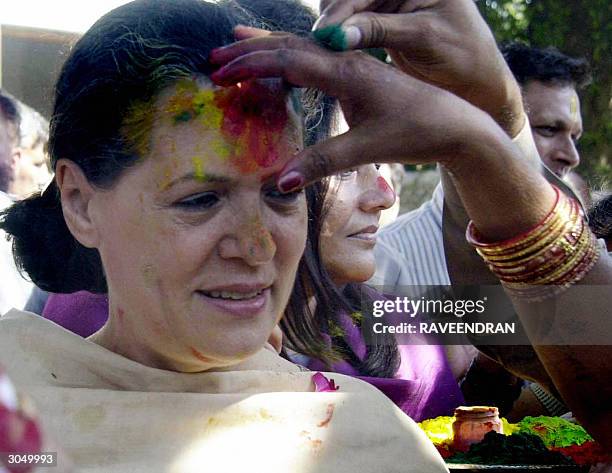 Indian Opposition leader and Congress Party President Sonia Gandhi has coloured powder applied to her forehead during celebrations for 'Holi' at her...