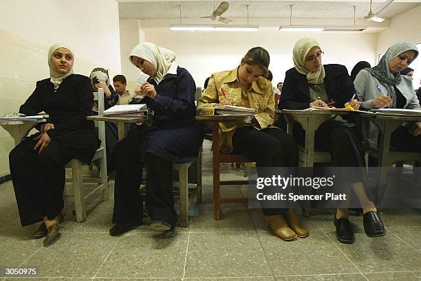 Female students take notes in a math class at Baghdad University March 7, 2004 in Baghdad, Iraq. Baghdad University, the nation's largest college,...
