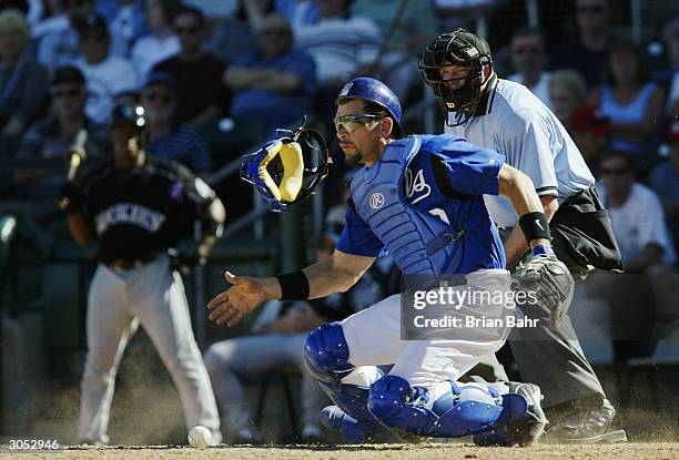 Catcher Benito Santiago of the Kansas City Royals jumps to stop a pitch in the dirt during a game against the Colorado Rockies on March 7, 2004 at...