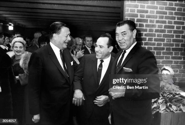 American restauranteur Bernard Toots Shor , American baseball player Yogi Berra, and American boxer Jack Dempsey laugh at the opening of Shor's new...