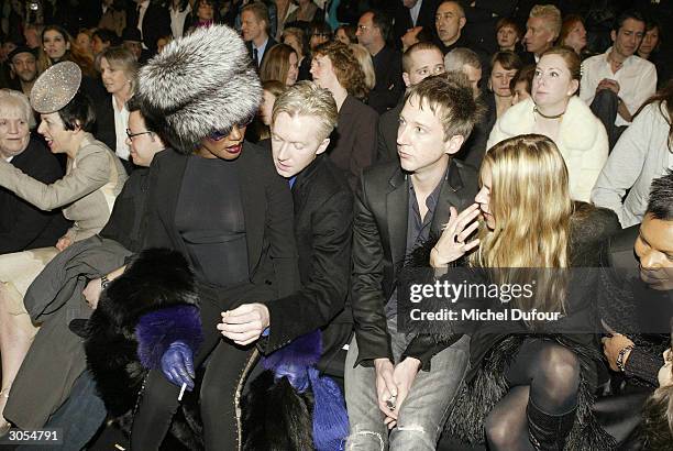 Model Grace Jones sits on designer Philip Treacy's knee next to Kate Moss and Jefferson Hack during the Alexander McQueen ready-to-wear Fall-Winter...