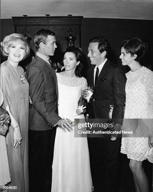 Actor Edie Adams, TV host Johnny Carson and his wife Joanne, singer Andy Williams and his wife Claudine Longet attend a party at a nightclub, circa...