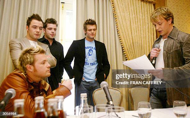 Westlife band members Nicky Byrne , Shane Filan , Mark Feehily , Bryan McFadden listen while Kian Egan reads a statement at press conference to...