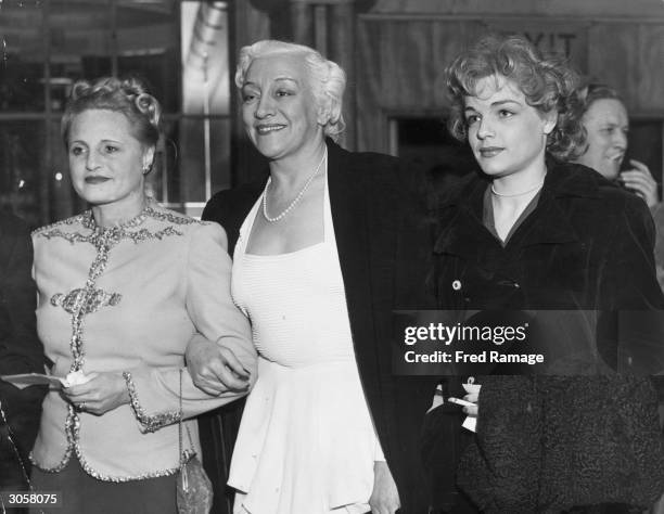 From left to right, the wife of film producer Michael Balcon and French actresses Francoise Rosay and Simone Signoret attend the London premiere of...