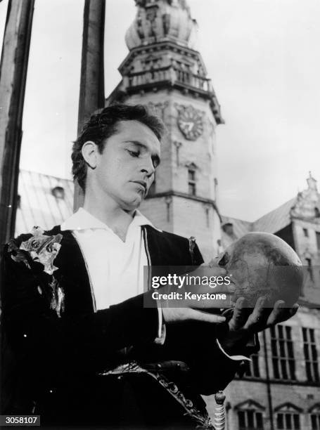 Welsh actor Richard Burton contemplates a skull at Kronberg Castle, Elsinore, where he and the Old Vic Company are staging a performance of...