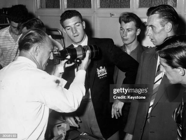 From left to right, Fred Goodwin, Bill Foulkes, Kenny Morgans, Ray Wood and Dennis Viollet of Manchester United FC watch a camera salesman...