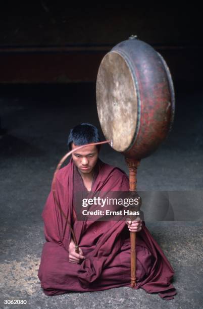 Monk from the Paro Valley holds a large gong like percussion instrument.