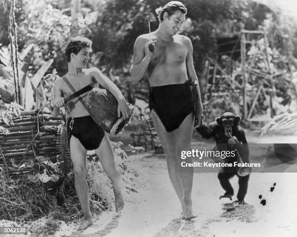 American actor and Olympic swimmer Johnny Weissmuller as Tarzan with Johnny Sheffield as Boy and the chimpanzee Cheetah.