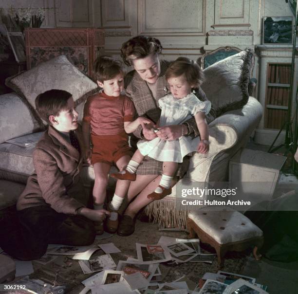 Fifties mother divides her attention up between her baby daughter and two young sons.