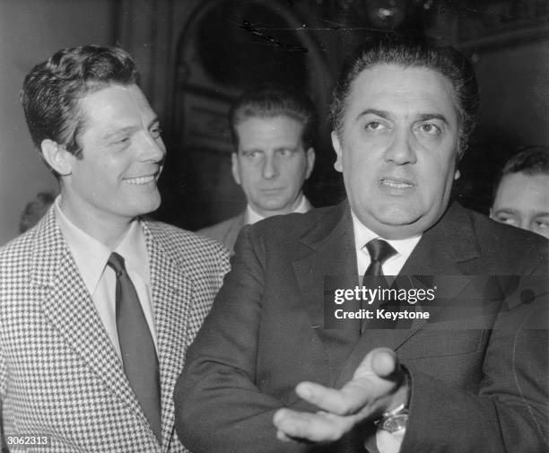 Italian filmmaker Federico Fellini with the actor, Marcello Mastroianni, during a press conference in Paris promoting the film 'La Dolce Vita'