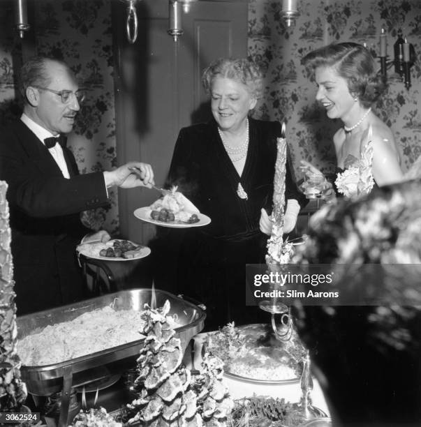 American actress Lauren Bacall hosting a party on Christmas Eve at the Bogart family home in Beverly Hills, California. Groucho Marx and Ethel...