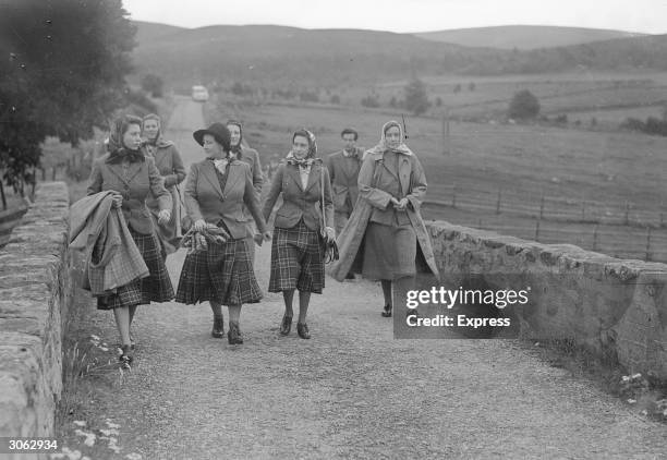 Queen Elizabeth with her daughters, the princesses Elizabeth and Margaret on holiday in Scotland. Bringing up the rear of the royal group is Group...