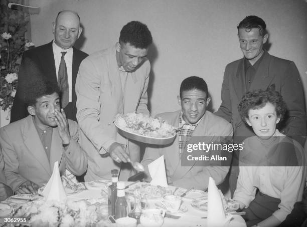 British middleweight boxer and European Champion Randolph Turpin eating with his brother Dick Turpin and family.