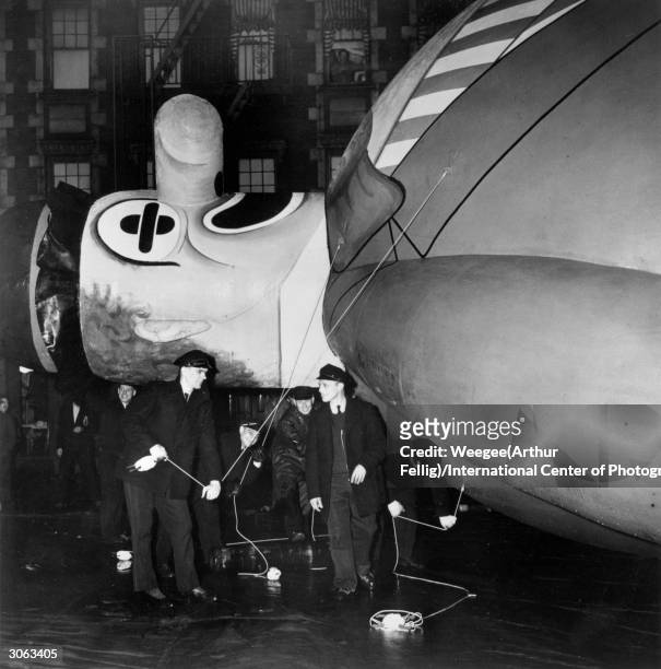 The crew prepare to erect the giant inflatable Macy's Bobo the Hobo balloon for the Macy's Parade, New York, November 1945. This annual procession is...
