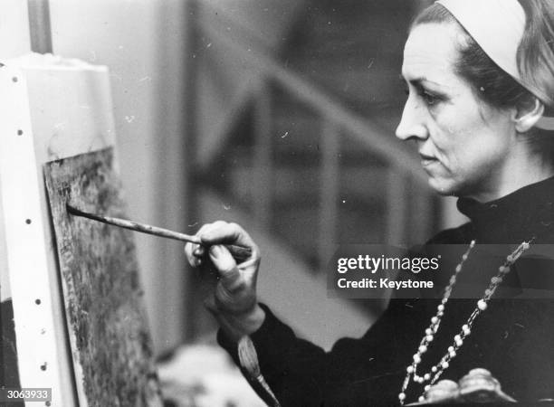 French artist Francoise Gilot, who had two children by Pablo Picasso paints in her studio in Fulham, London.