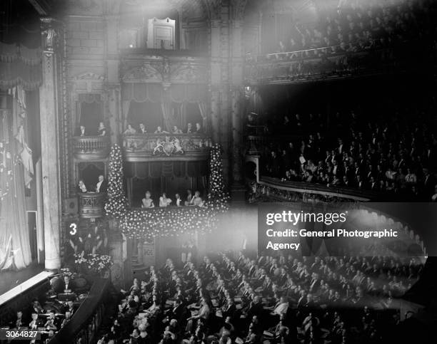 Music hall audience in a crowded theatre, the boxes including the royal box are full and act No3 is on stage.