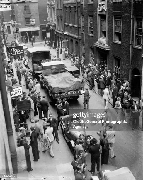 In Archer St, Soho, London musicians gather in groups waiting to see if there is any work available.