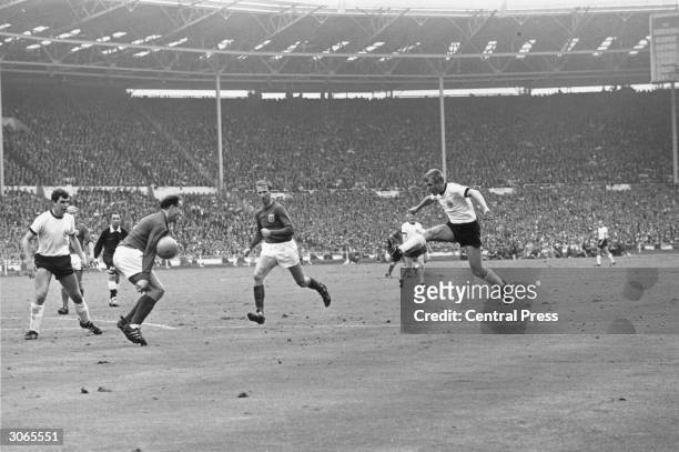 English footballer Jackie Charlton watching his teammate George Cohen block a shot by the German forward Siegfried Held during the World Cup final at...