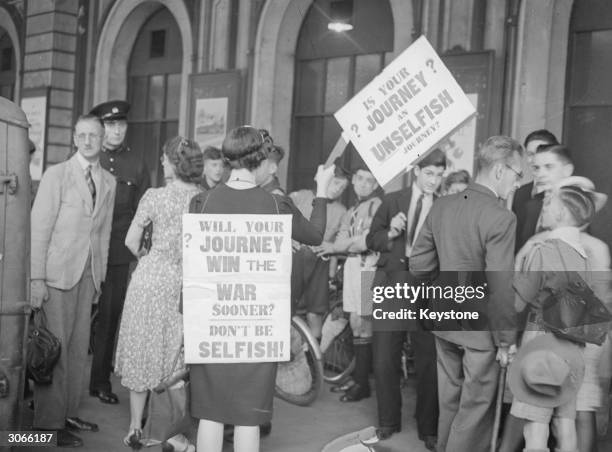 Mrs Hoyer of Kensington, London a war-widow parading with anti-travel posters among the holiday makers at Paddington, station, London.