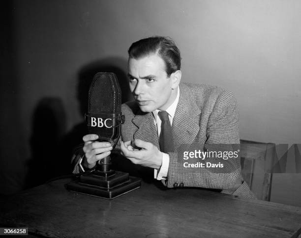 Radio actor Gordon Davies, the new 'Dick Barton', clutches the BBC microphone during a particularly exciting part of the adventure series.