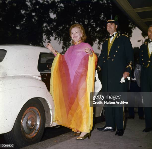 Aided by a doorman, British actress Olivia De Havilland leaves the Dorchester Hotel in London for a dinner date with British prime minister Edward...