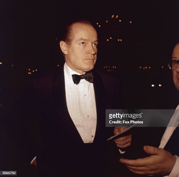 American movie icon Bob Hope arrives at a social function wearing a jacket and bow tie.
