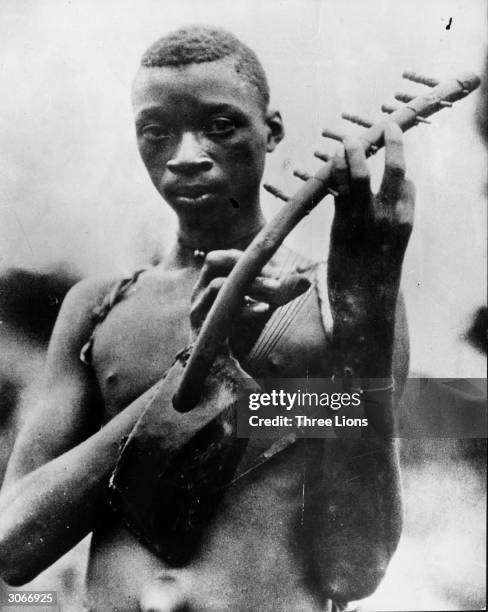 Man holding a stringed instrument in Leopoldville, now Kinshasa, capital of the Democratic Republic of the Congo.