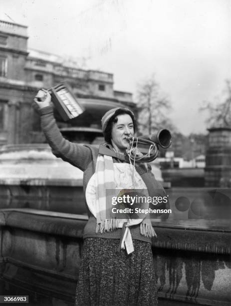 Portsmouth soccer supporter in Trafalgar Square, London blows a horn and waves a rattle. She is in London to watch an FA Cup match.