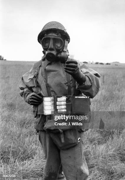 Sergeant Gordon Beard of the RAF Regiment wearing protective clothing and using a residual vapour detector at Porton Down in Wiltshire.