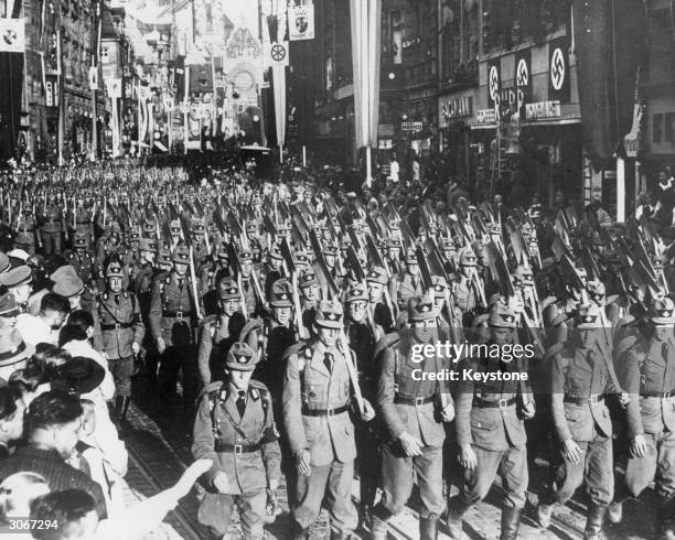 Nazi soldiers parade through cheering crowds in pre-war Italy.