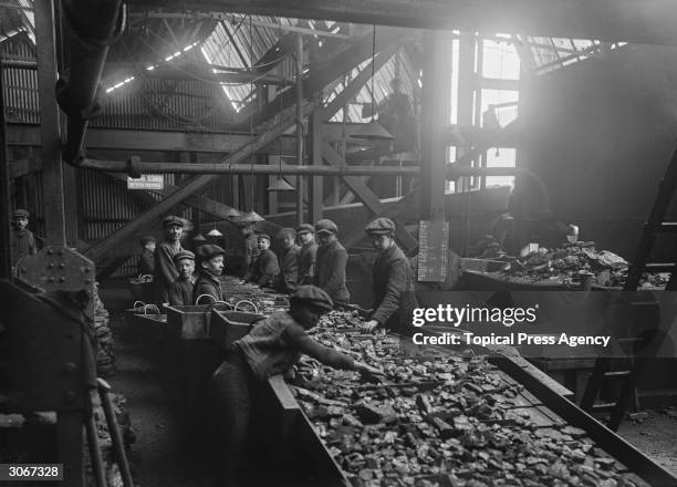 Young boys at work at the troughs used for cleaning coal at a pit in Bargoed, South Wales.