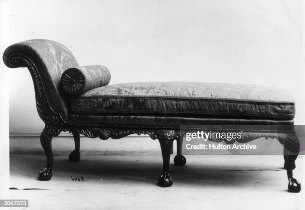 Carved chaise longue with a bolster pillow.