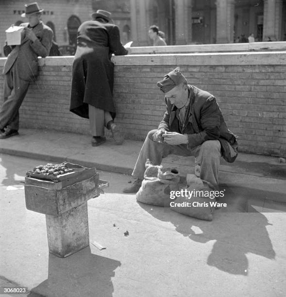 In post war Rome an old soldier roasts chestnuts on the street.