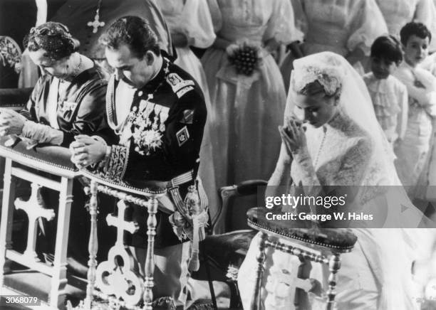 Prince Rainier of Monaco with his bride, Her Most Serene Highness Princess Grace Patricia , praying during their wedding service in Monaco Cathedral.