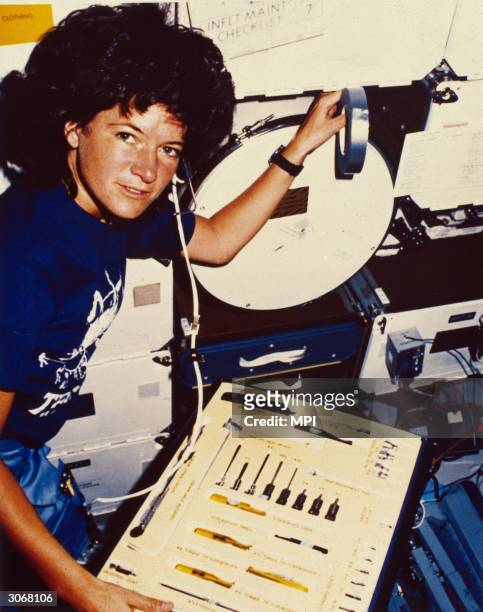 Astronaut Sally Kirsten Ride, the first American woman in space inspects the array of tools at her disposal during her earth orbit in the Challenger...