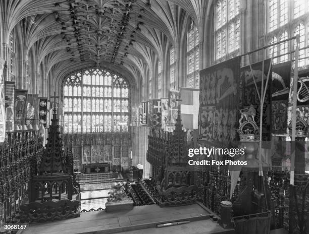 Interior of St George's chapel, Windsor Castle with intricate fan vaulted ceiling and 15th century panel tracery window over the altar.