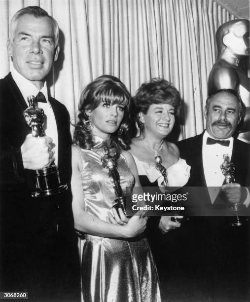 Four Oscar winners holding their statuettes after the ceremony at the Civic Auditorium, Santa Monica. From l to r; Lee Marvin , Julie Christie ,...