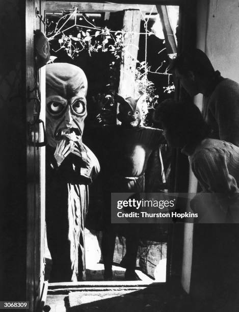 American actress Barbara Bates and her husband Michael watching guests arrive at a fancy dress hallow'een party. Original Publication: Picture Post -...