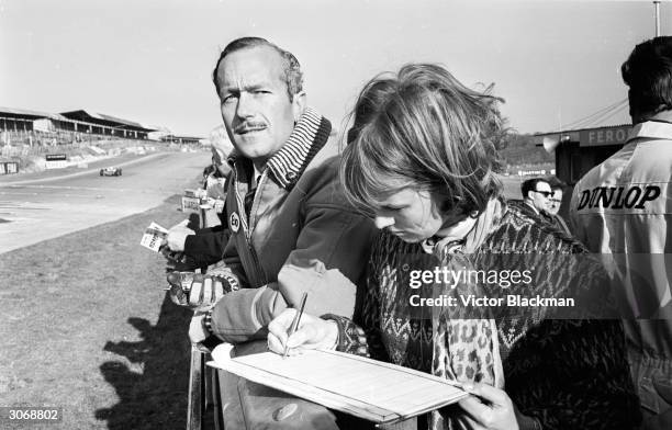 British racing driver and car designer Colin Chapman , the founder of Lotus at the Brands Hatch track in Kent.