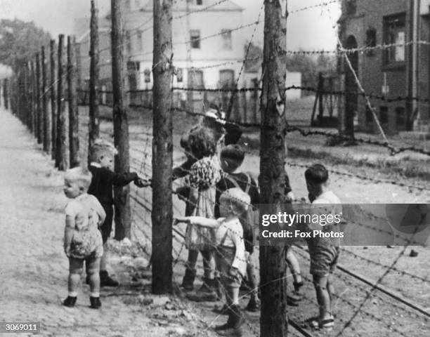 Two Dutch children pass food to their German friends in the post-war village of Kerkrade, which the Allied authorities have divided into Dutch and...