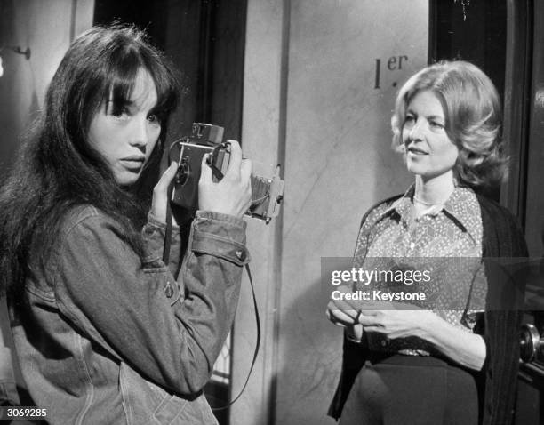 French actress Isabelle Adjani takes a photograph of Nicole Courcel between takes of Claude Pinoteau's film 'La Gifle' at the Billancourt Studios.