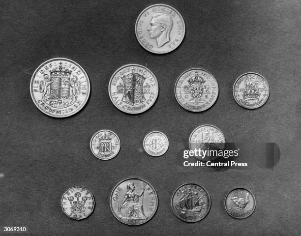 Close-up of a set of the new English coins minted for the reign of King George VI, including a crown, a half crown, a two shilling piece, a shilling,...