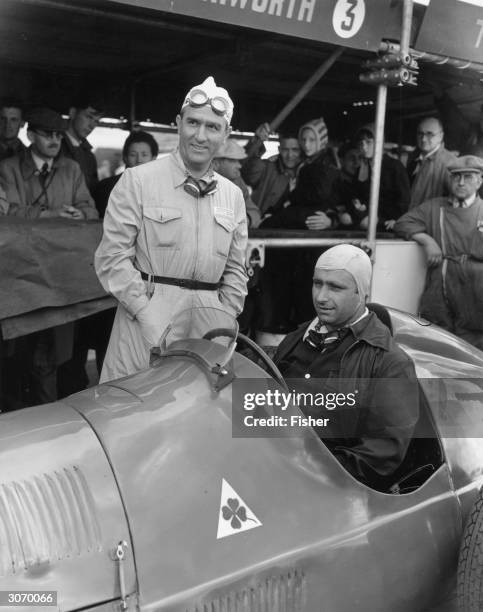 At Silverstone, Alfa Romeo team racing drivers, Dr Giuseppe Farina and in the driver's seat Juan Manuel Fangio .