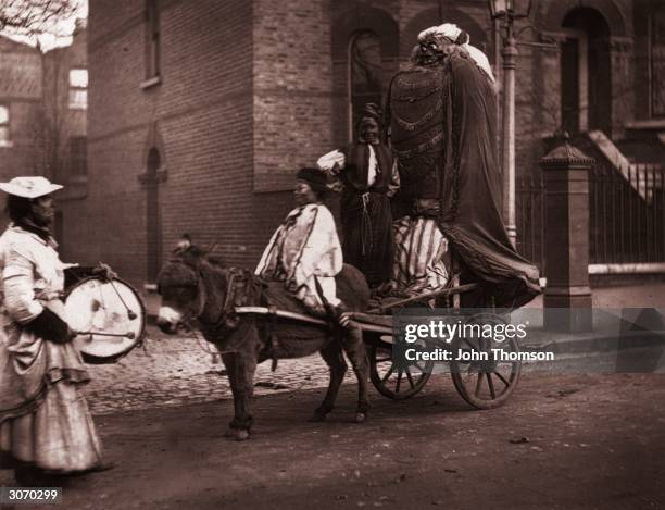 Giant guy is mounted on a donkey and cart for a procession through the streets on Bonfire Night. Original Publication: From 'Street Life in London'...