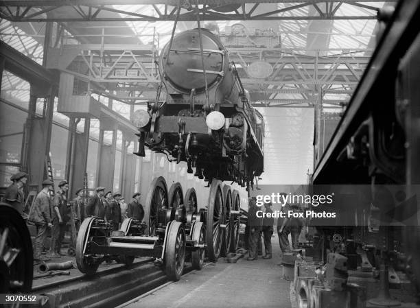 Locomotive being lowered on to bogie wheels at Southern Railway works, Eastleigh, Hampshire.