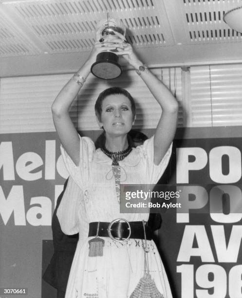 Britain's top female singer, Julie Driscoll holds her trophy aloft after the Melody Maker Pop Poll Awards.
