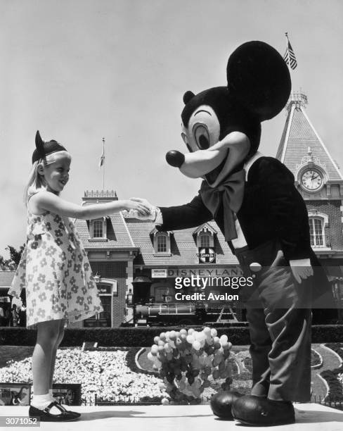 Young girl at Disneyland, California, shaking hands with Mickey Mouse during the 40th anniversary of his creation by Walt Disney.
